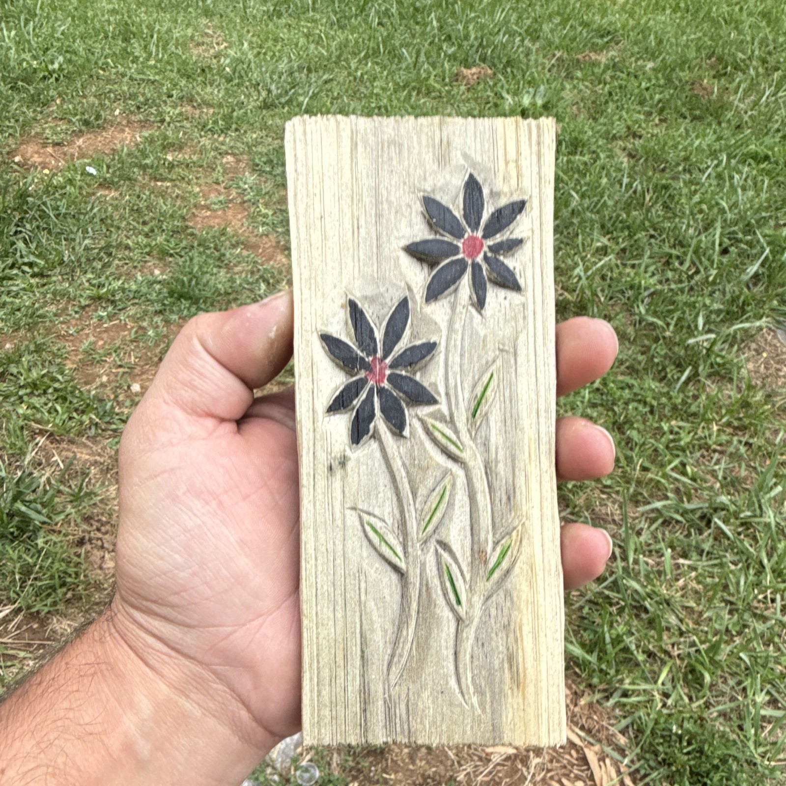Hand carved and painted flower carved into a piece of pine wood