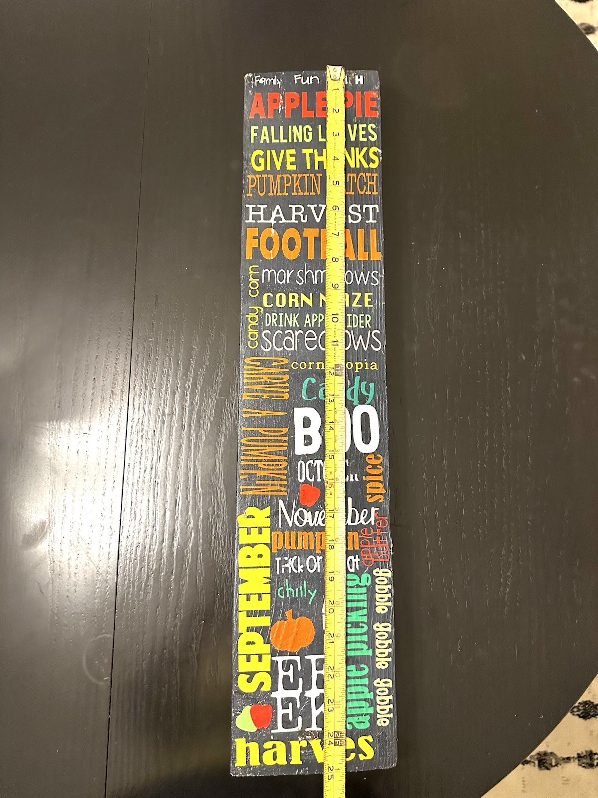 Wooden 25” porch leaner features a collage of fall activities & holidays