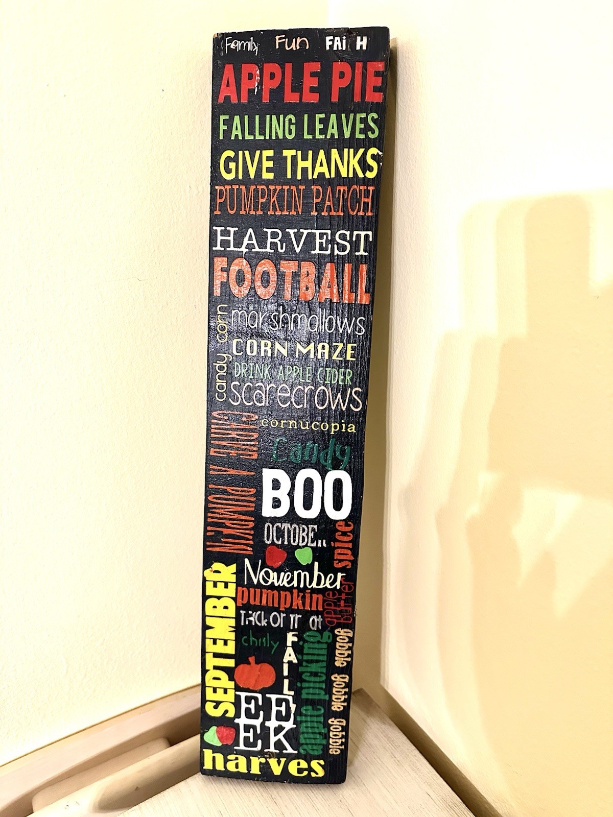 Wooden 25” porch leaner features a collage of fall activities & holidays